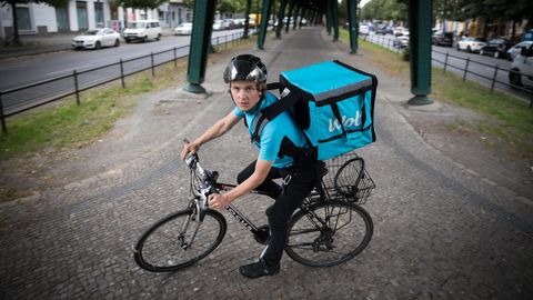 Ein Lieferant auf dem Fahrrad blickt in die Kamera