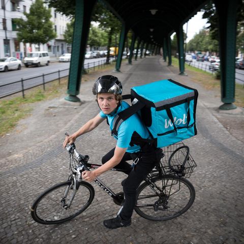 Ein Lieferant auf dem Fahrrad blickt in die Kamera