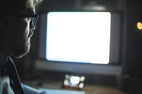 Mann in einem dunklen Raum vor Monitor