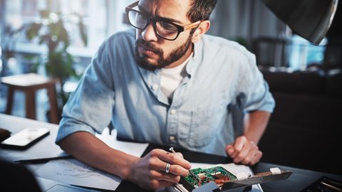 Raspberry-Pi-Projekte: Ein Mann schraubt an einem kleinen Computer.