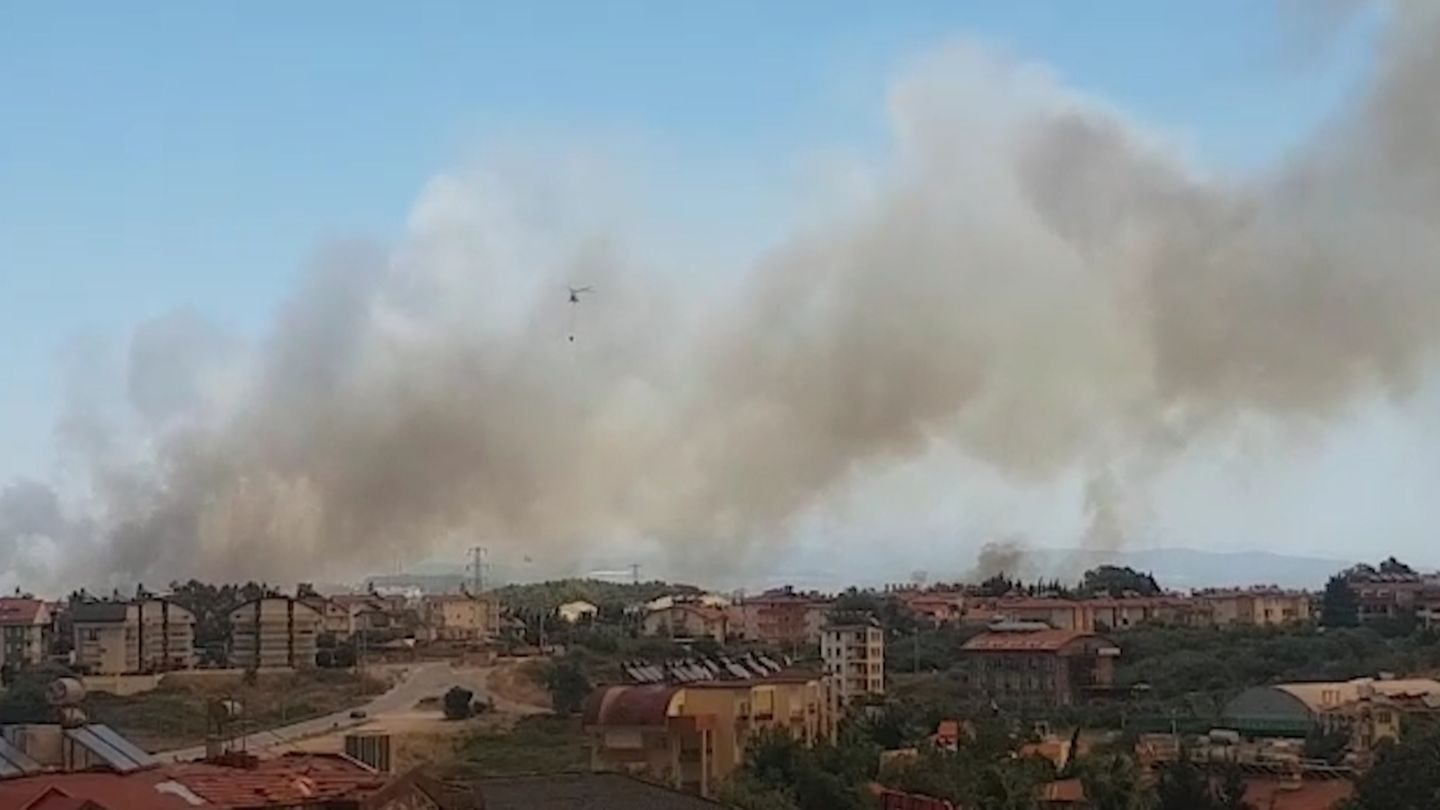 Dunkler Rauch steigt über einem Wohngebiet in den Himmel auf