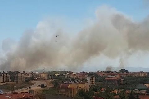 Dunkler Rauch steigt über einem Wohngebiet in den Himmel auf