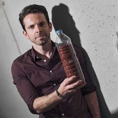 cirplus-Gründer Christian Schiller mit einer Plastikflasche voll recyceltem Kunststoff