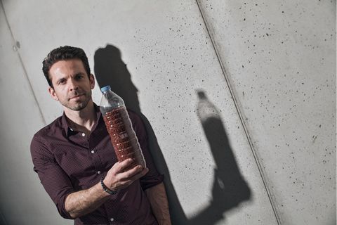 cirplus-Gründer Christian Schiller mit einer Plastikflasche voll recyceltem Kunststoff