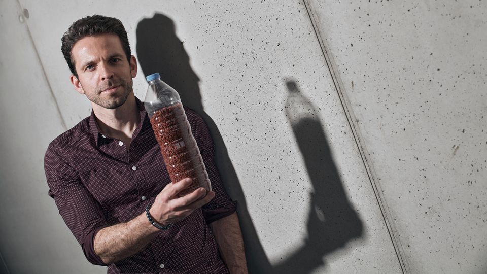 cirplus-Gründer Christian Schiller mit einer Plastikflasche voll recyceltem Kunststoff