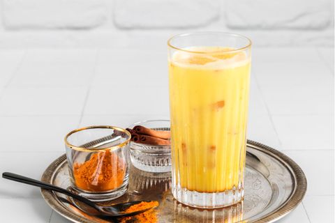 Ein Iced Kurkuma Latte mit Gewürzen auf einem Tablett