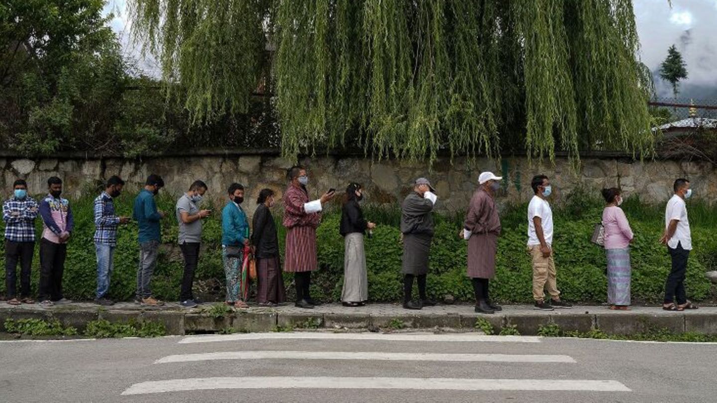 Menschen stehen in Bhutans Hauptstadt Thimpu in der Schlange, um sich gegen das Coronavirus impfen zu lassen