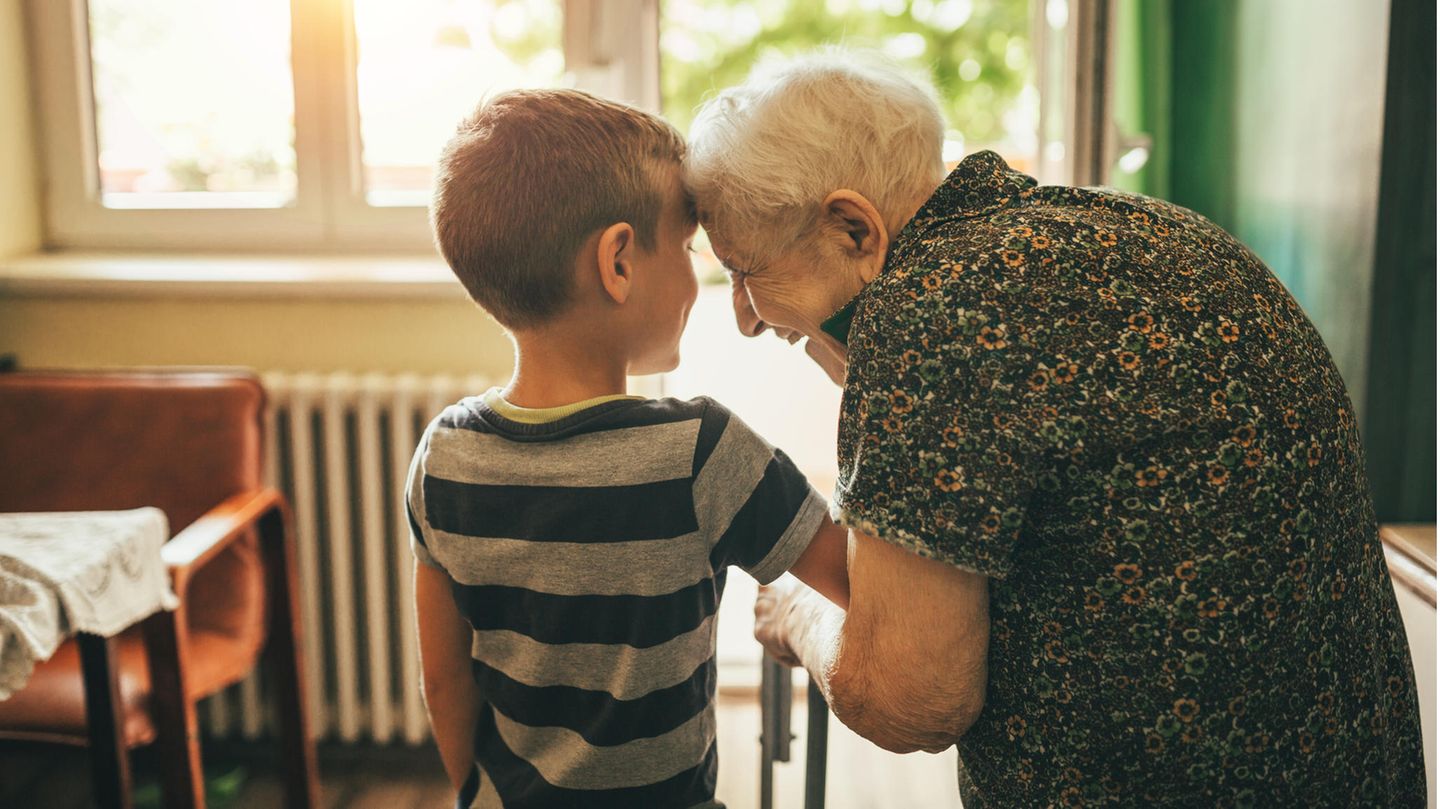 Ältere Dame und kleiner Junge lächeln sich an