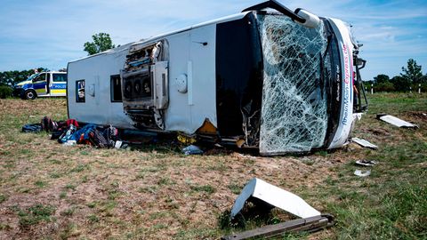Ein Reisebus liegt auf der Seite, die Windschutzscheibe ist zersplittert