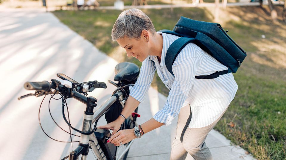 Eine Frau schraubt an ihrem Fahrrad
