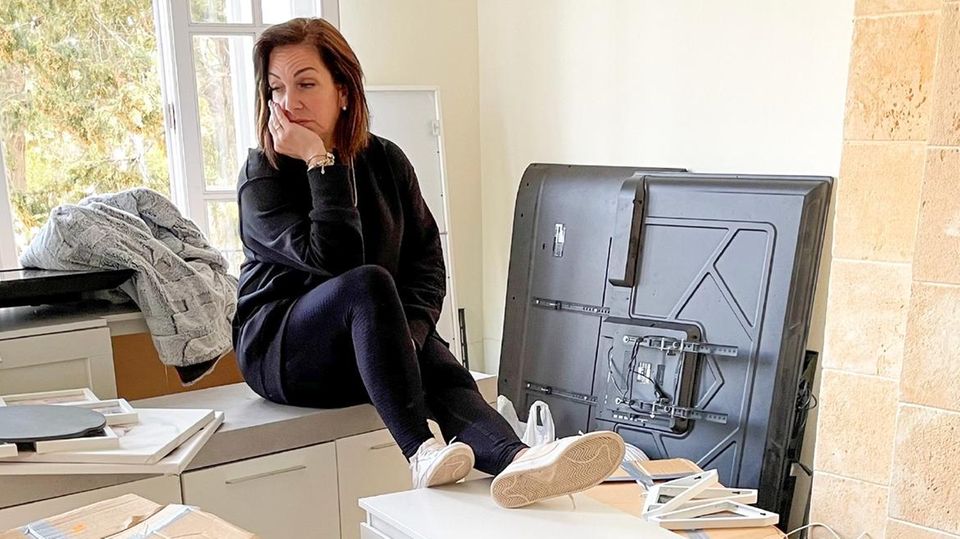Danni Büchner sitzt in ihrem neuen Wohnzimmer zwischen Kisten.