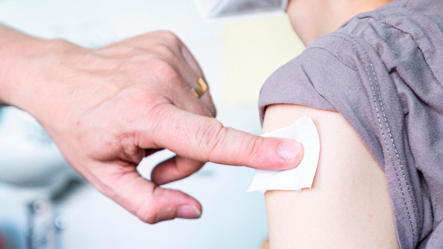 A pediatrician pushes a swab to the place where a young woman was vaccinated