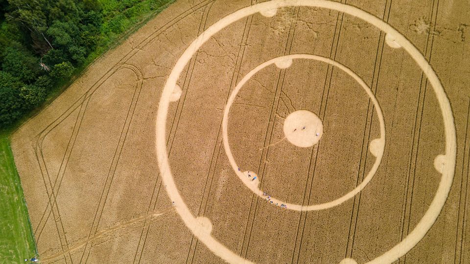 Kornkreis in Gauting Menschen laufen durch einen Kornkreis in einem Weizenfeld im bayerischen Gauting