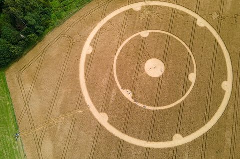 Menschen laufen durch einen Kornkreis in einem Weizenfeld im bayerischen Gauting