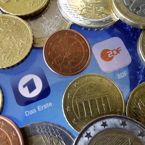 Euromünzen liegen neben den Logos der Apps von ARD und ZDF