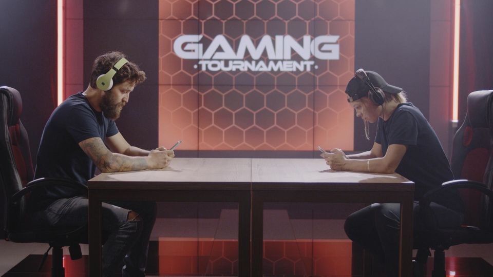 Gaming-Handy: Zwei Kontrahenten sitzen sich gegenüber und spielen am Smartphone.