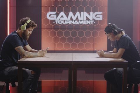 Gaming-Handy: Zwei Kontrahenten sitzen sich gegenüber und spielen am Smartphone.