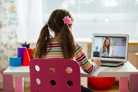 Schülerin am Schreibtisch mit Lehrerin auf dem Laptop