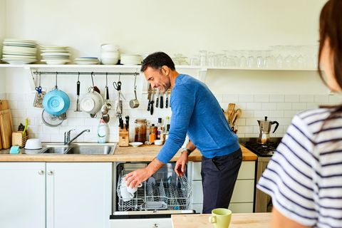 Mann räumt Geschirrspüler ein