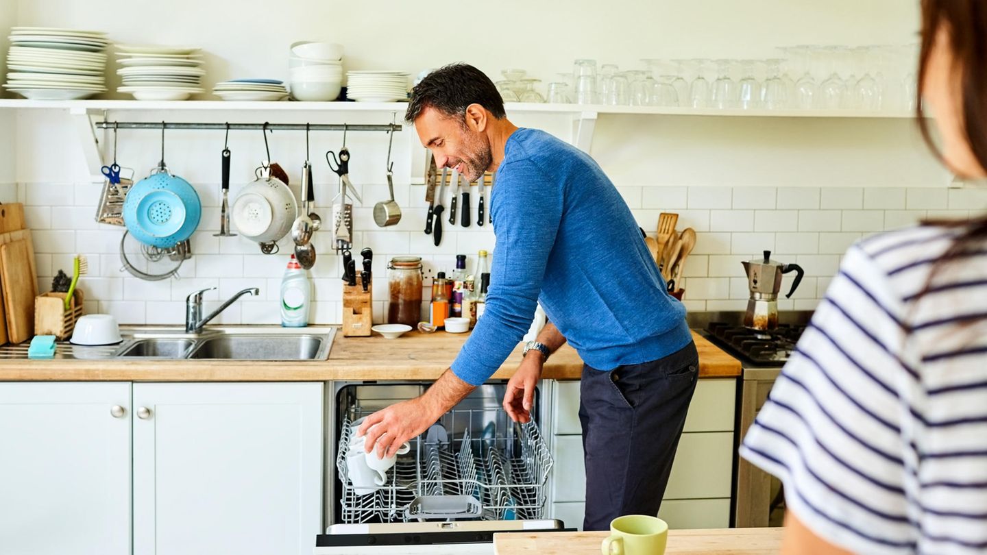 Mann räumt Geschirrspüler ein