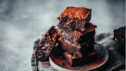 Diese Brownies sind außen hellbraun und innen dunkelbraun und stehen auf einem kleinen Teller
