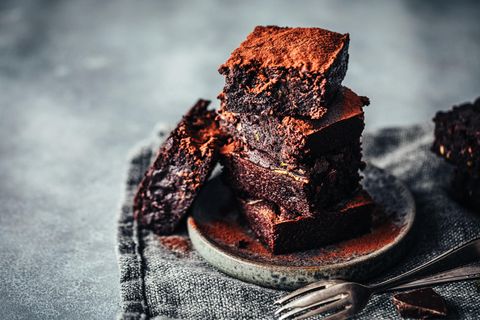 Diese Brownies sind außen hellbraun und innen dunkelbraun und stehen auf einem kleinen Teller