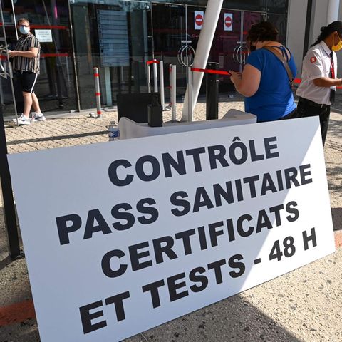 Besucher zeigen ihren Covid-Pass, den "pass sanitaire" vor einem Kino in der französischen Stadt Montpellier