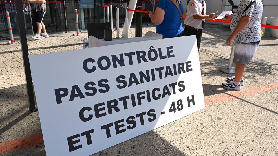 Besucher zeigen ihren Covid-Pass, den "pass sanitaire" vor einem Kino in der französischen Stadt Montpellier