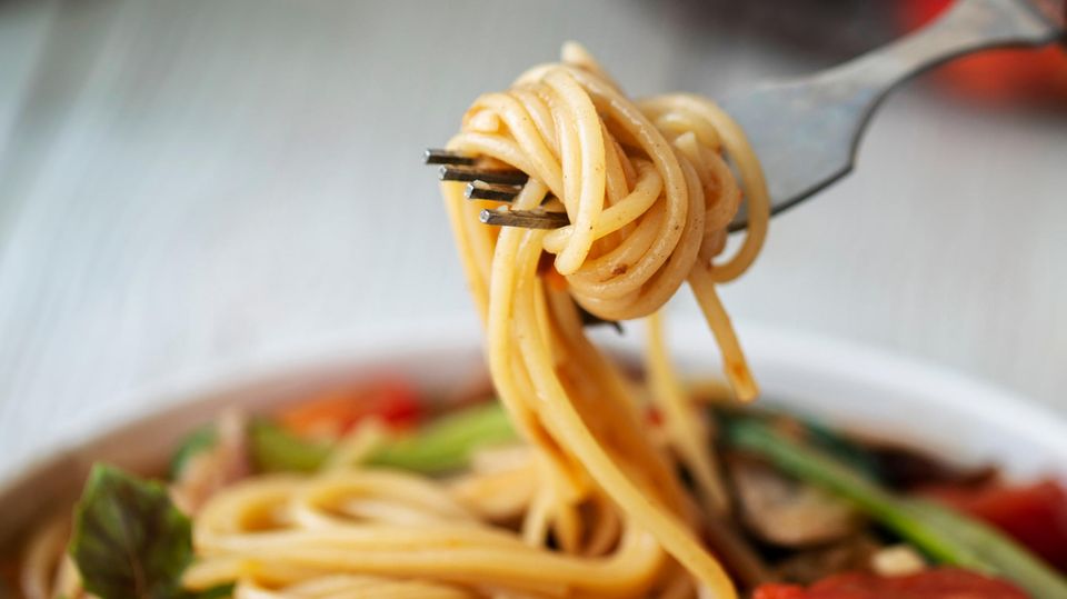 Spaghetti werden auf eine Gabel aufgewickelt.