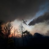 Athen, Griechenland. Ein Flugzeug wirft über einem Waldbrand Löschwasser ab.