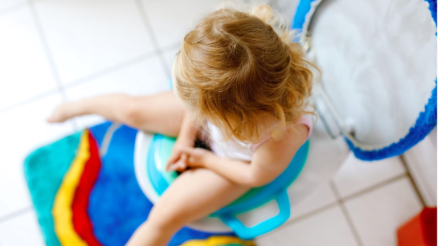 Toilettensitze für Kinder: Kleines Mädchen hockt auf einem Toilettentrainer