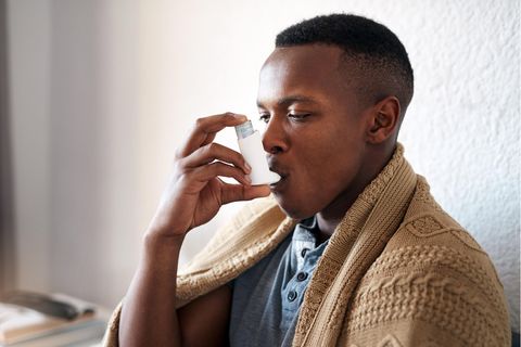Mann benutzt Asthmaspray