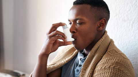 Mann benutzt Asthmaspray