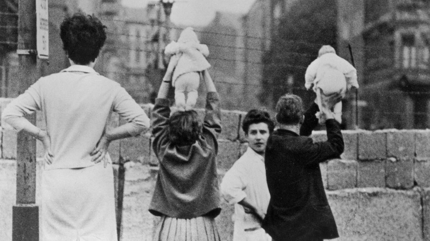 Eltern zeigen den Großeltern im Osten ihre neugeborenen Zwillinge über die neu errichtete