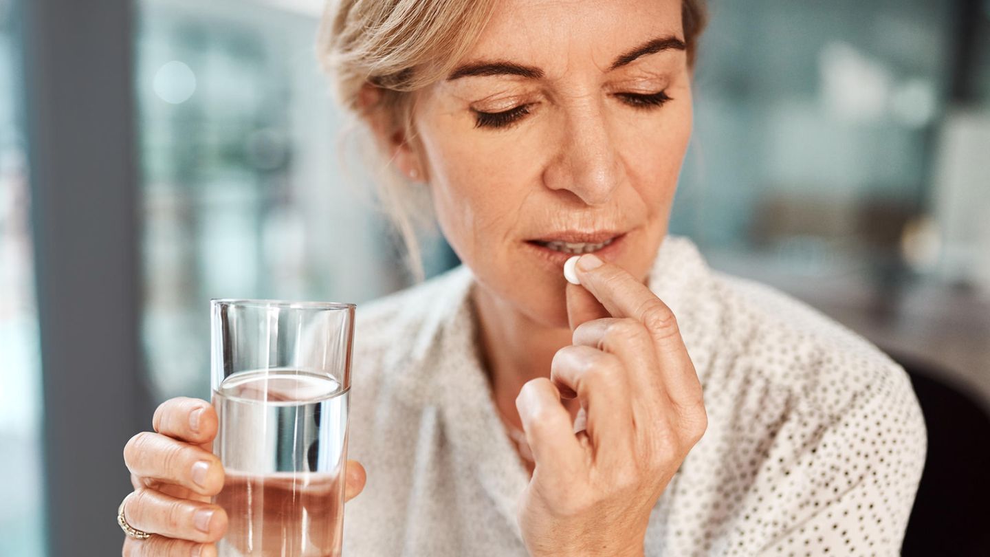 Voll auf die Nieren: Wie Nahrungsergänzungsmittel unsere Gesundheit gefährden können Frau nimmt eine Nahrungsergänzungskapsel