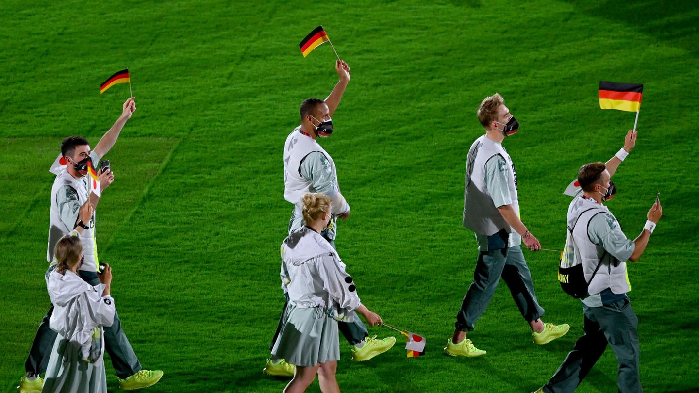 Deutsche Sportlerinnen und Sportler laufen während der Abschlusszeremonie über den Rasen.