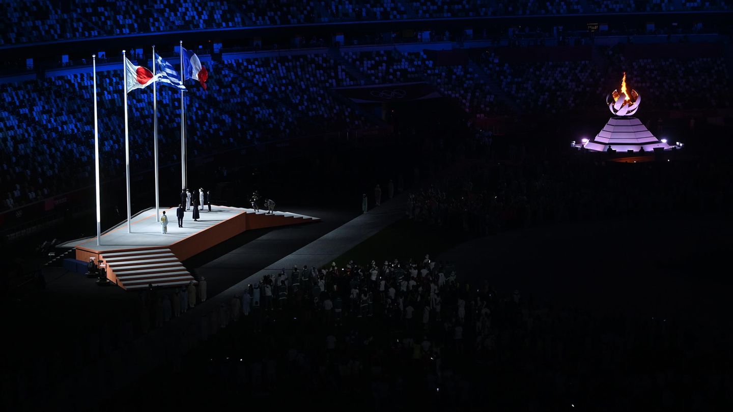 Die Fahnen von Japan, Griechenland und Frankreich sind gehisst. Rechts: das olympischen Feuer.