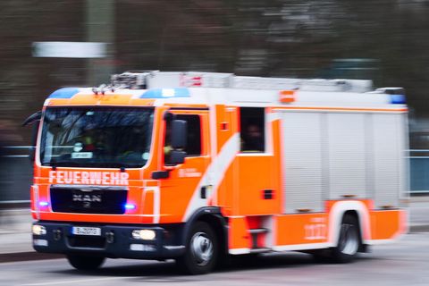 Ein Fahrzeug der Feuerwehr fährt bei einem Blaulichteinsatz über eine Straße in Berlin (Archivfoto)