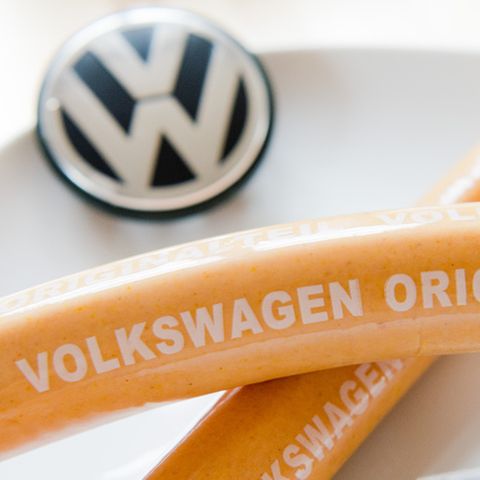 Zwei Currywürste liegen auf einem Teller mit VW-Firmenlogo