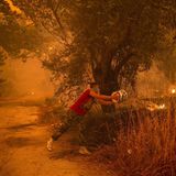 So wie hier in dem Ort Gouves muss zur Not ein Eimer Wasser herhalten, um gegen die zerstörerische Gewalt des Feuers anzukämpfen.