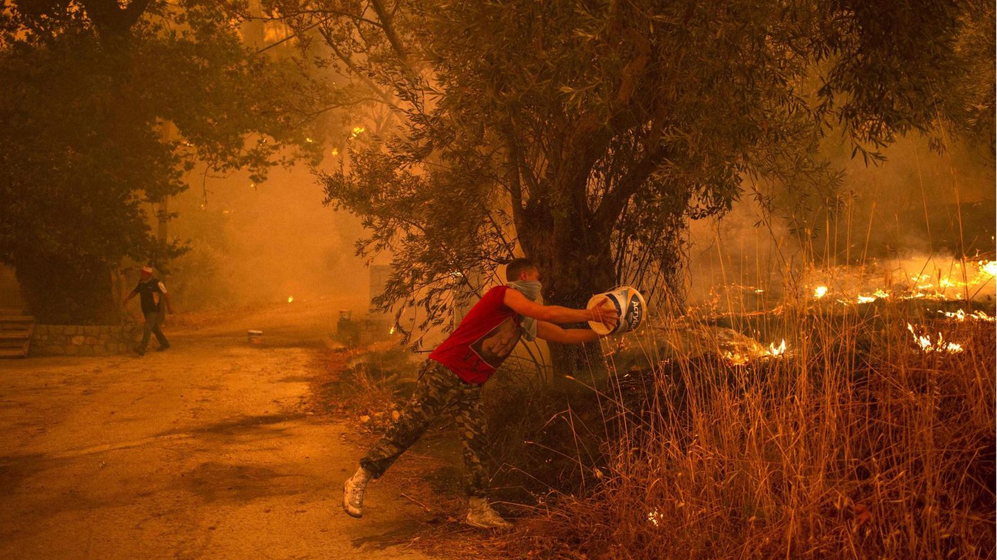 So wie hier in dem Ort Gouves muss zur Not ein Eimer Wasser herhalten, um gegen die zerstörerische Gewalt des Feuers anzukämpfen.