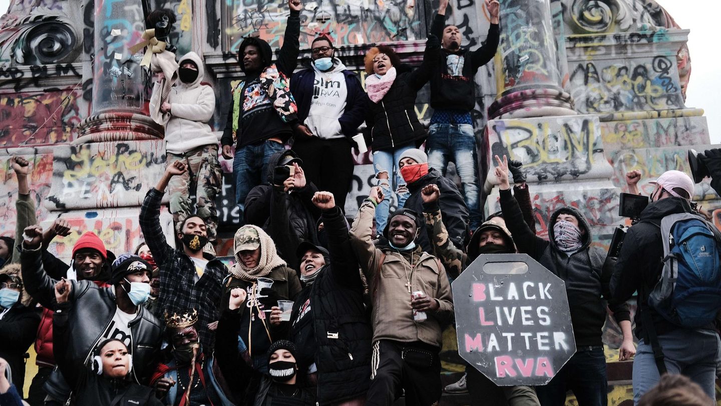 Demonstrierende der Black Lives Matter Bewegung im Januar 2021 vor der beschmierten Statur von Robert E.
