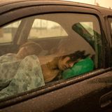 Einige organisieren sich eigene Not-Schlafplätze. Diese Frau und eine Jugendliche übernachten im Auto am Strand von Pefki, wo sie vor den Flammen sicher sind.