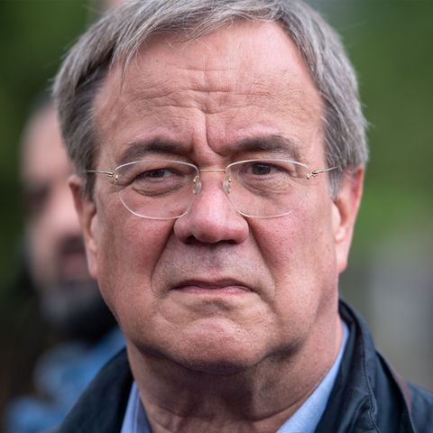Ein weißer, älterer Mann mit angegrautem Seitenscheitel und randloser Brille schaut ernst