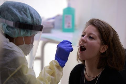 Eine DRK-Mitarbeiterin demonstriert an einer jungen Frau die Prozedur des Abstrichs für einen Corona-Test.