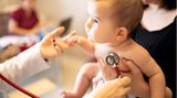 Das Baby hält den Kopf  Das Baby wird immer beweglicher. Im sechsten bis siebten Lebensmonat führt es dem Kinderarzt vor, wie gut es seinen Körper schon beherrscht. Meist kann es sich schon selbst auf den Bauch drehen. Wenn es auf dem Bauch liegt, sollte es sich mit beiden Armen abstützen können. Es kann jetzt mit seinen Händchen zwei Finger des Arztes umfassen und sich daran hochziehen. Der Arzt wird auch prüfen, ob es seinen Kopf gut halten kann, wenn es sitzt. Und schließlich sollte es mit seinen Händen sicher Gegenstände greifen. Der Arzt beobachtet, wie der Säugling reagiert, wenn er ihn anspricht, anschaut und bestimmte Geräusche macht. Das Baby wird sich jetzt der Geräuschquelle zuwenden und den Arzt gezielt anschauen. Schielt das Kind? Das kann der Arzt mit einem Augenspiegel erkennen.  Nutzen Sie jede Untersuchung, um mit dem Arzt über alles zu sprechen, was Ihnen aufgefallen ist. Er wird Sie vermutlich fragen, ob Sie dem Kind weiterhin Vitamin D geben, um eine Rachitis zu vermeiden, und Fluor, damit sich seine Zähne gut entwickeln. Und er bespricht mit Ihnen, welche weiteren Impfungen anstehen. Am Ende des sechsten Lebensmonats Ihres Kindes wird er Ihnen raten, spätestens jetzt zusätzlich zum Stillen zuzufüttern - am besten mit einem Gemüse-Kartoffel-Fleisch Brei.