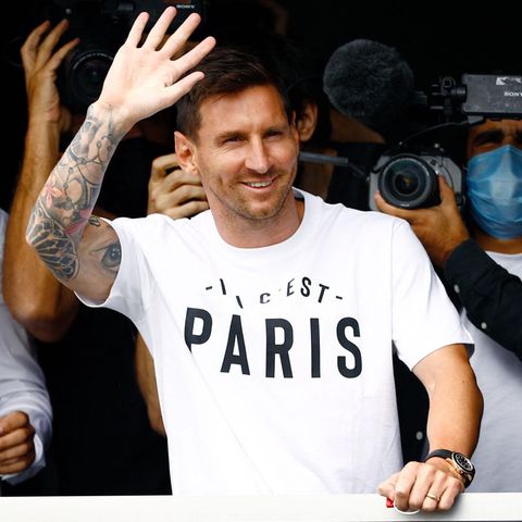 Da ist er: Lionel Messi ist mit viel Rummel und Getöse in Paris eingetroffen und winkt den Fans am Flughafen. 