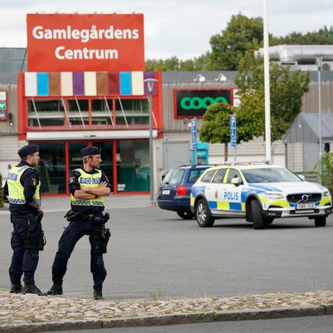 Zwei Polizisten sichern nach Schüssen auf einem Parkplatz im Kristianstader Stadtteil Nasby den Tatort