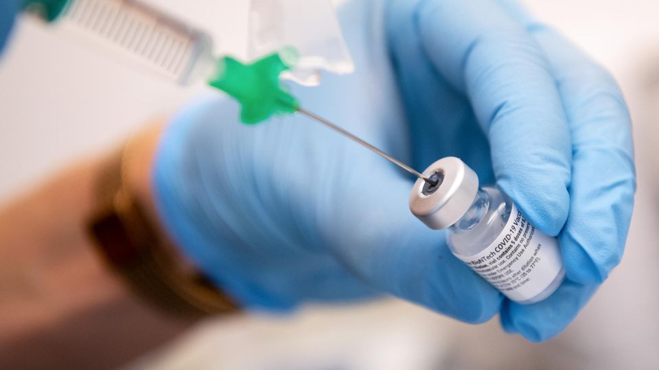 Eine Klinik-Mitarbeiterin zieht den Covid-19-Impfstoff von Biontech/Pfizer für eine Impfung auf eine Spritze