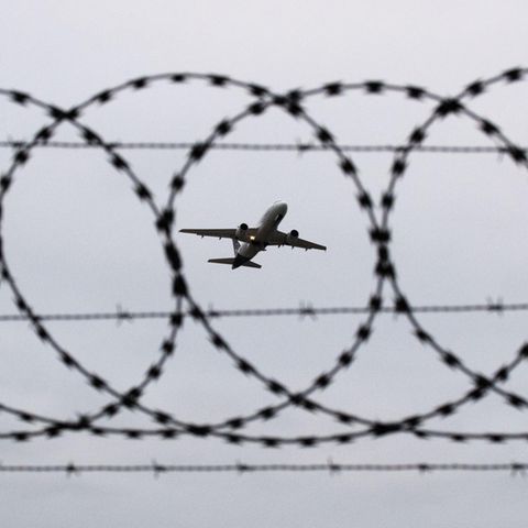 Ein Flugzeug startet am Flughafen Hannover – fotografiert durch Stacheldraht am Flughafenzaun